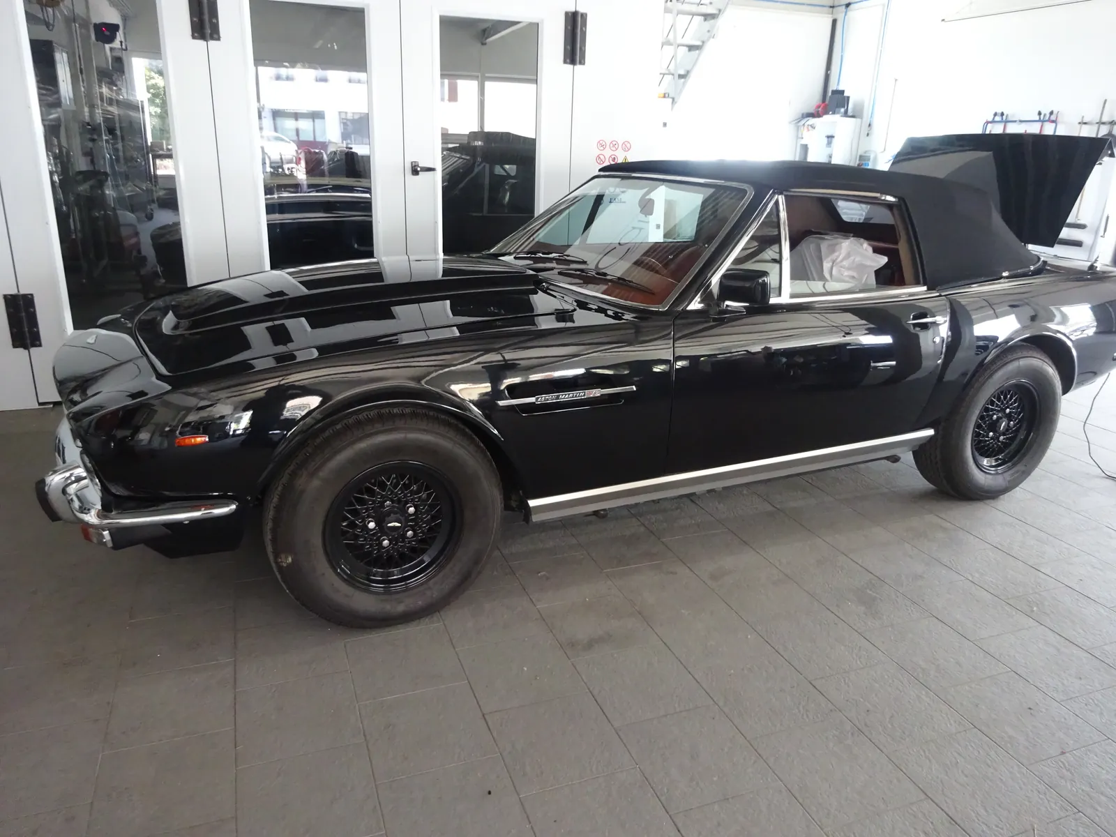 Aston Martin cabriolet noire dans l’atelier