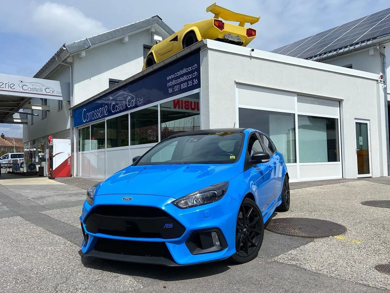Ford Focus RS bleue devant l’atelier