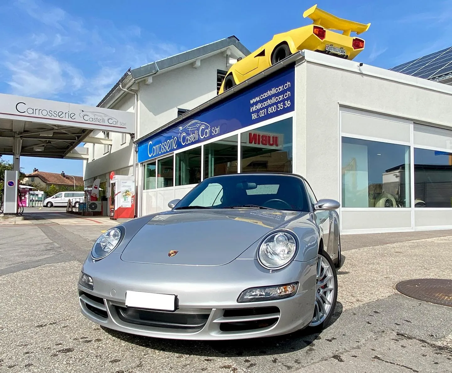 Porsche 911 grise devant l’atelier