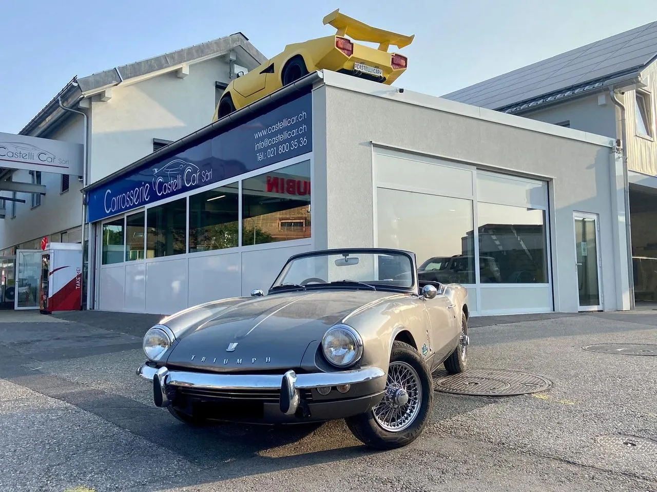 Triumph cabriolet devant l’atelier